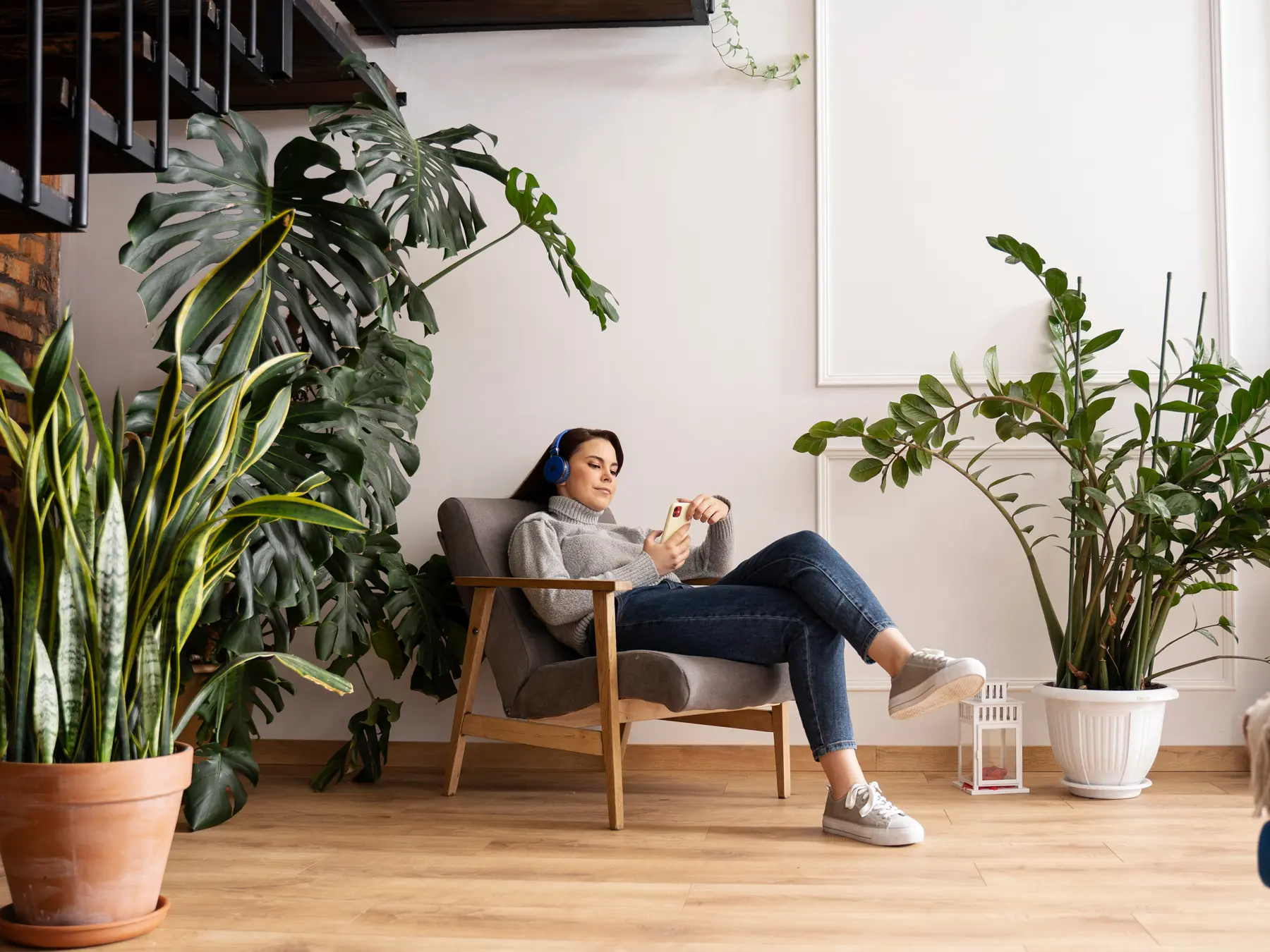 Große Wohnung oder kleines Haus? Wohnung kaufen Dortmund, Bild: Frau in sitzt im Sessel, großes geräumiges Wohnzimmer